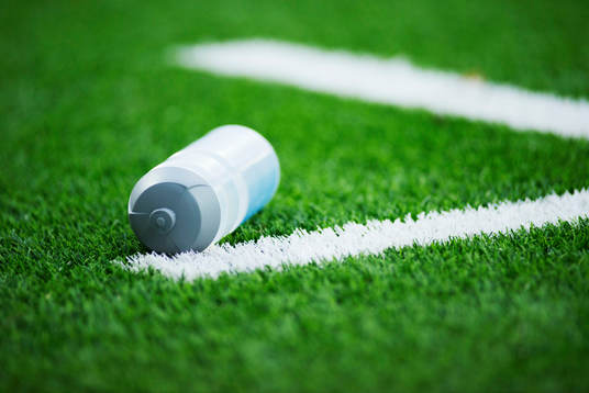 En vattenflaska ligger på fotbollsplanen