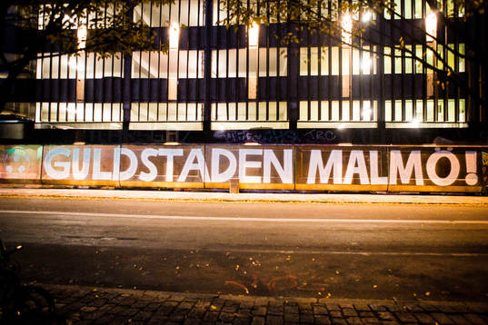 Texten Guldstaden Malmö skrivet på väggen av ett