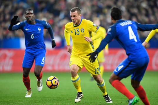 Sveriges Jakob Johansson framför Frankrikes Paul Pogba