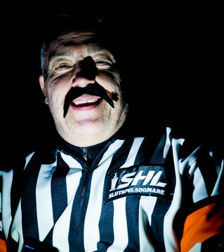 En i publiken med domartröja och lösmustach