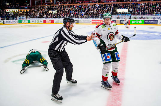Färjestads Oskar Steen ligger på isen och blöder medans