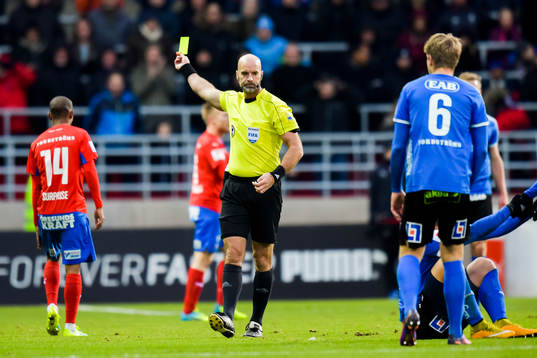 Domare Stefan Johannesson  delar ut ett gult kort till