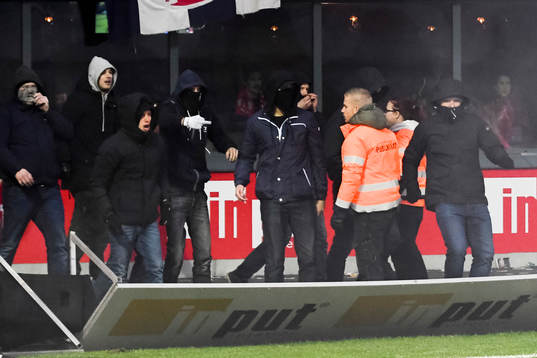 Supportar välter en reklamskylt när de stormar planen