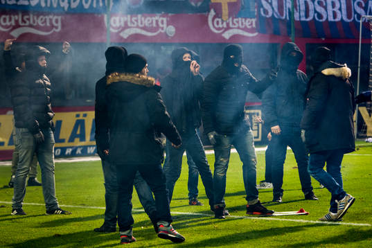 Maskerade supportrar stormar planen