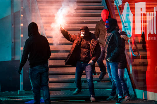 Maskerade supportrar stormar planen