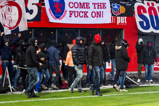 Maskerade supportrar stormar planen