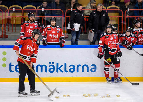 En funktionär skotar upp palt från isen