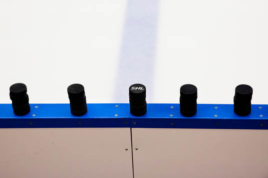 Puckar med SHLs logotype på sargkanten