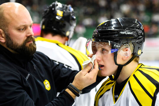 Brynäs Daniel Mannberg får hjälp att torka av visiret