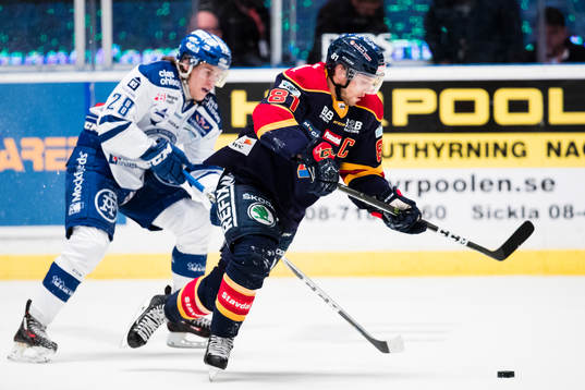 Leksands William Wikman i kamp om pucken med Djurgårdens