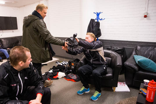 Bildbyråns fotograf Joel Marklund räcker över hjälmen
