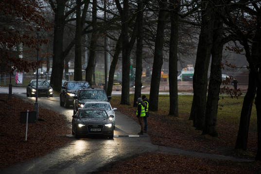 Publikvärdar tar emot bilar på evenemangsparkeringen