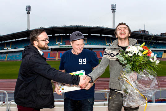 Martin Kihlström från Postkodlotteriet delar ut en check