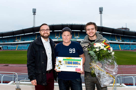 Martin Kihlström från Postkodlotteriet delar ut en check