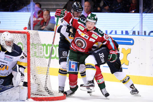 Frölundas Simon Hjalmarsson hålls fast av två