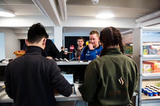 Människor i kö till kiosken