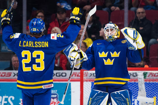 Sveriges Lucas Carlsson och målvakt Felix Sandström jublar