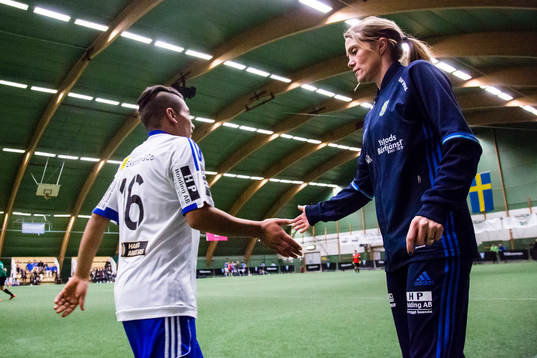 Ungdomsledare tar i hand med spelare vid ett byte