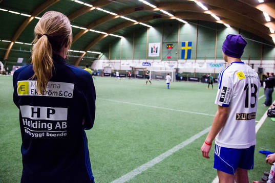 Ungdomsledare och spelare tittar på match
