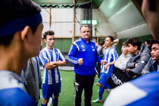 Spelare i Tomelilla IF lyssnar på sin ungdomsledare