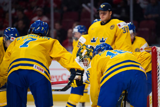 Sveriges spelare samlas runt sin målvakt Felix Sandström