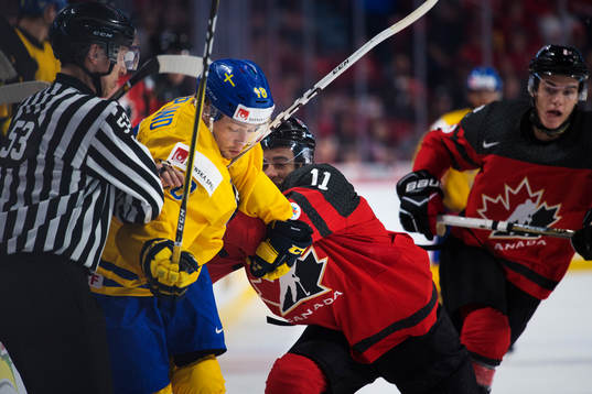 Sveriges Rasmus Asplund tacklas av Kanadas Mathieu Joseph