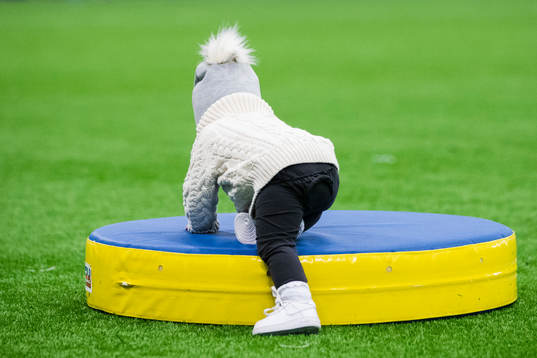 En liten flicka klättrar på en madrass