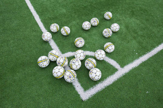 Bollar på konstgräset innan en fotbollsträning med