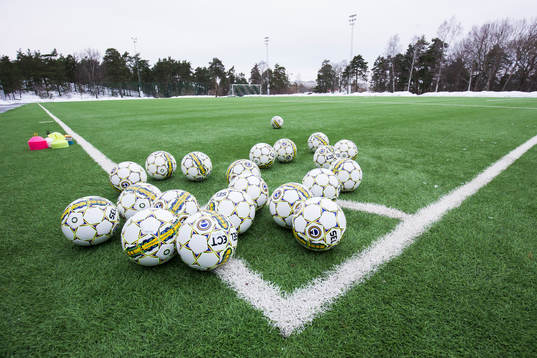 Bollar på konstgräset innan en fotbollsträning med