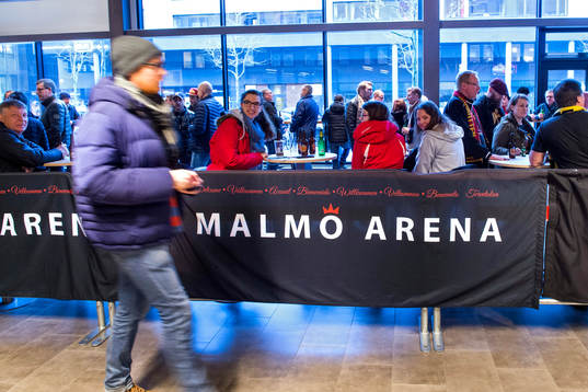 En man går förbi en skylt där det står Malmö Arena