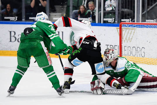 Malmö Redhawks Nils Andersson framför Rögles målvakt