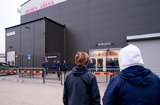 Några ungdomar tittar på Djurgårdensspelarna som värmer