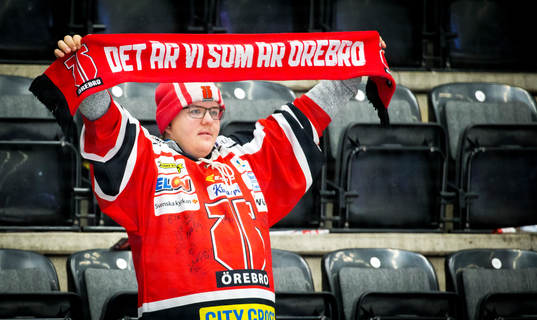 En Örebrosupporter håller upp en halsduk med texten Det