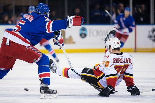 Rangers Dan Girardi tacklar Calgarys Micheal Ferland