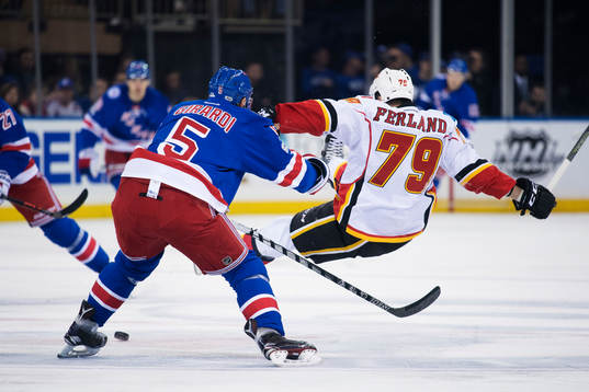 Rangers Dan Girardi tacklar Calgarys Micheal Ferland