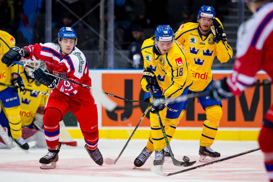 Sveriges Dennis Everberg med pucken jagad av Tjeckiens