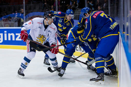 Kamp om pucken vid sargen mellan Finlands Tommi Kivistö