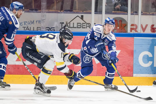 s Erik Andersson i kamp om pucken i ishockeymatchen i SHL