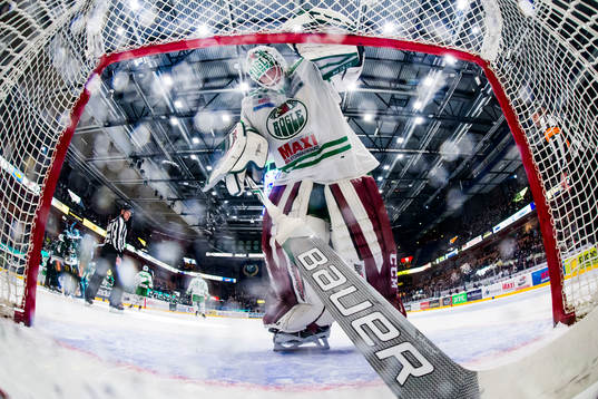 Rögles målvakt Anders Lindbäck hämtar ut en puck ur