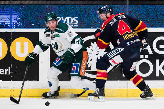 Färjestads John Persson i kamp om pucken med Djurgårdens