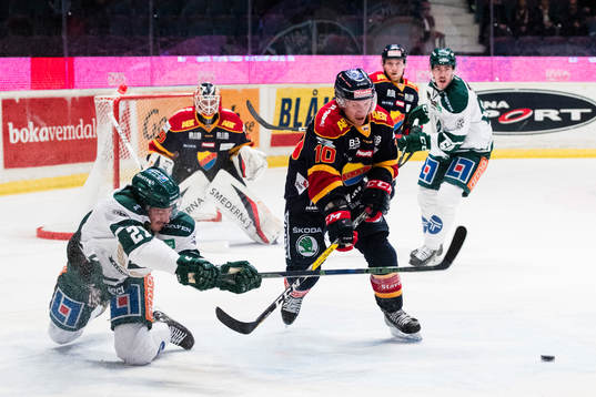 Färjestads John Persson i kamp om pucken med Djurgårdens