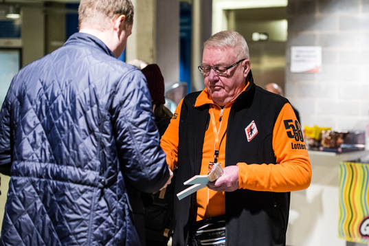 volontär som säljer 50/50 lotter innan  ishockeymatchen i