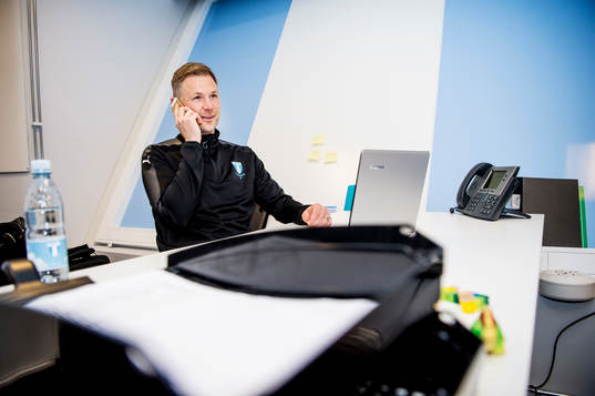 Huvudtränaren i Malmö FF, Magnus Pehrsson, med telefon i