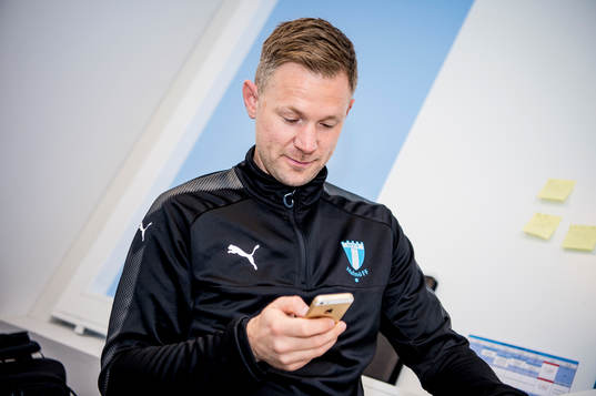 Huvudtränaren i Malmö FF, Magnus Pehrsson, med telefon i