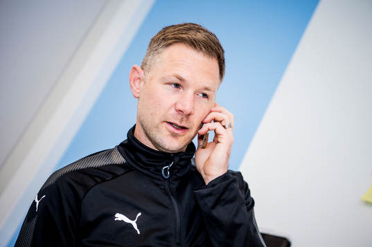 Huvudtränaren i Malmö FF, Magnus Pehrsson, med telefon i