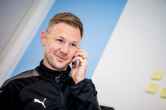 Huvudtränaren i Malmö FF, Magnus Pehrsson, med telefon i
