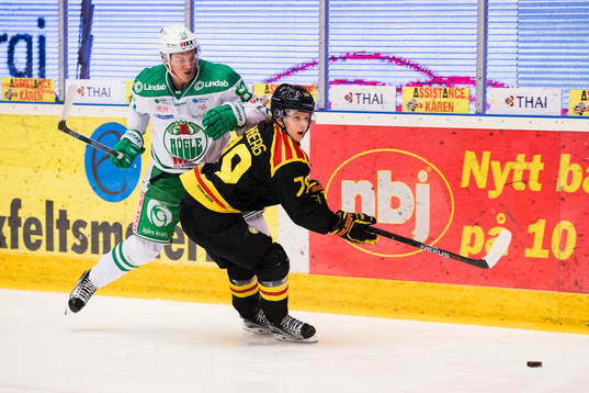 Rögles David Åslin i kamp om pucken med Brynäs Daniel