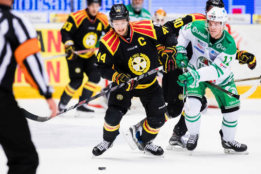 Brynäs Jacob Blomqvist i kamp om pucken med Rögles Bryan