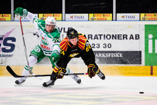 Rögles Filip Karlsson i kamp om pucken med Brynäs