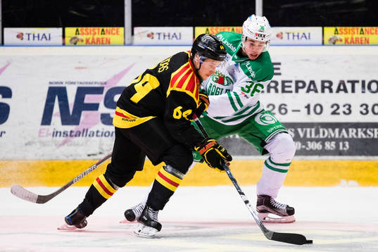 Rögles Filip Karlsson i kamp om pucken med Brynäs